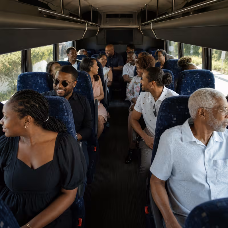 Group boarding a white charter bus for Private Event Transportation transportation in Birmingham