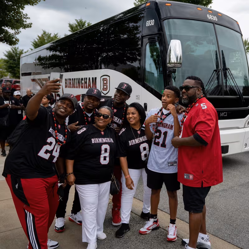 Passengers loading luggage while boarding an Birmingham group shuttle