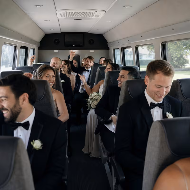 Group boarding a white charter bus for Wedding Transportation transportation in Birmingham